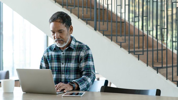 Imagen: Un hombre buscando información en su computadora portátil.