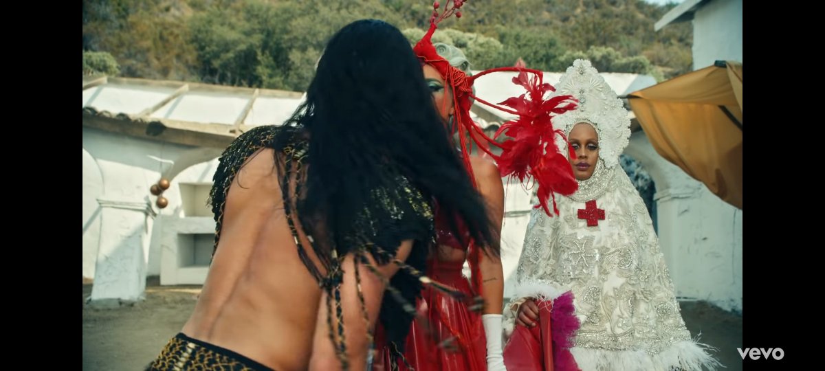 We see then how Gaga with a headpiece that looks like the respiratory system or a bird. They keep trying to get her back to life, the guy approaches to give her CPR (why he opens his mouth) and sort of grabs her ankle to say you& #39;re trapped in this cycle (checking her foot irl)