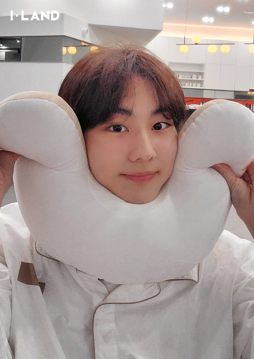 Jaywon wearing their neck pillows in matching stylish ways
