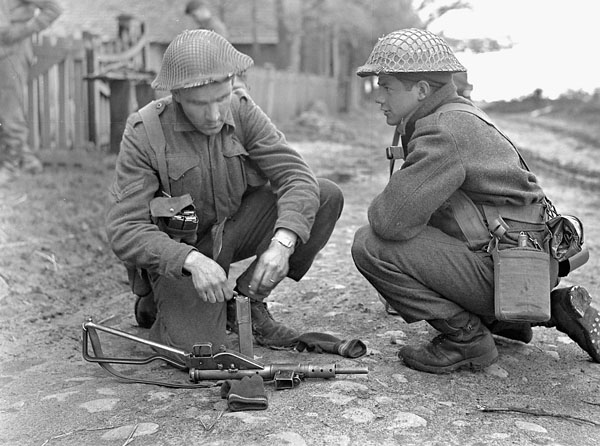 Been doing some research focused on infantry weapons recently for the PhD. Saw this great photo posted by  @Medical_Int which shows Infantrymen of Les Fusiliers Mount-Royal, one bombing up a Sten mag. THREAD.