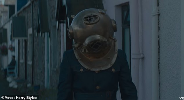 He hides away, losing his 'smile,' which meant that he had lost himself. He hides away under the metaphorical weight of the clunky old school diving suit helmet. The skies were quite gloomy in eroda for the peculiar boy.