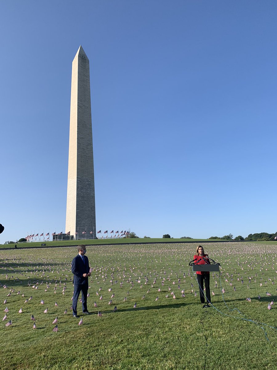 PELOSI, standing before flags remembering the COVID-19 victims: “It is time for us to crush this virus.”