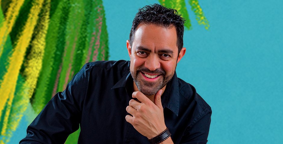 ZIENCuentos posing in front of a blue color and green leaves background