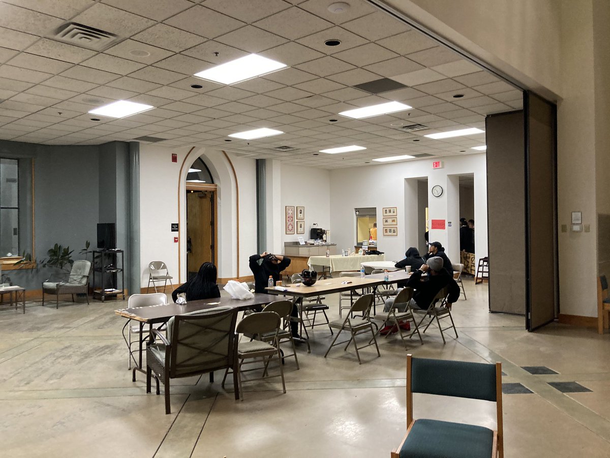 Inside the church, you can hear Amal group conversations and the sounds of the crowd outside, blue and red lights flash through the stained glass windows.