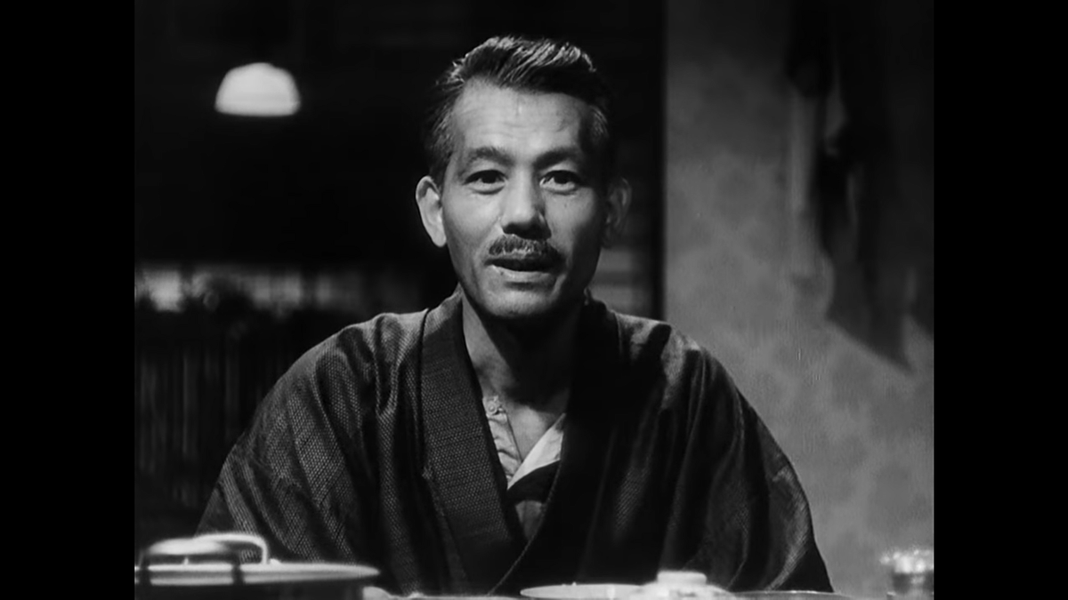 Ozu spends more time on Shukichi in this shot/reverse shot sequence as his response to this new information is more important and more in line with the audience’s situation.