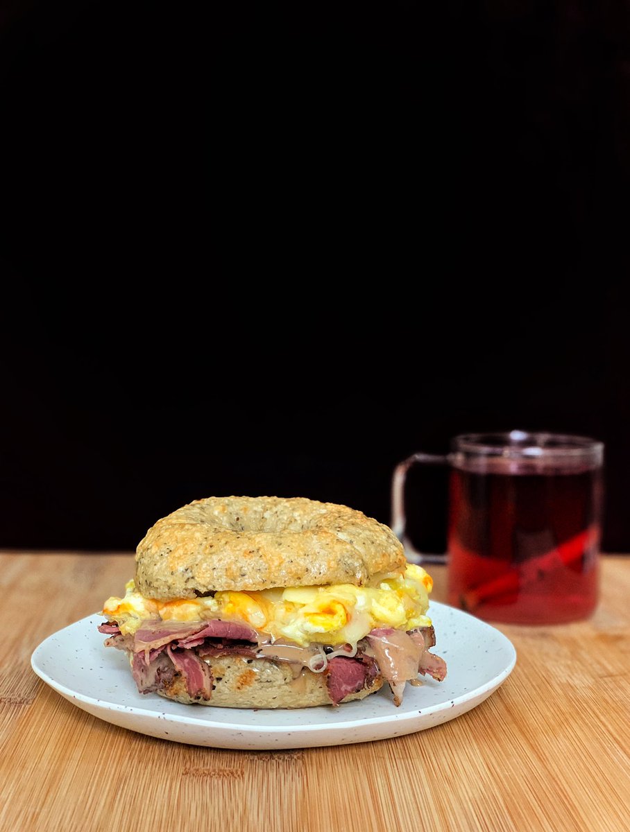 y’all truly living meaningless lives if you think that a breakfast sandwich can only have bacon or sausage • @mamalehs pastrami •scrambled eggs •muenster •maple dijon • @LevendBagelry cheddar herb bagel blackcurrant tea with cinnamon in the glass  #humblebragdiet