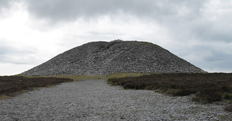 in a 12 m high stone monument on the summit of Knocknarea in County Sligo. She is supposedly buried upright facing her enemies in Ulster.