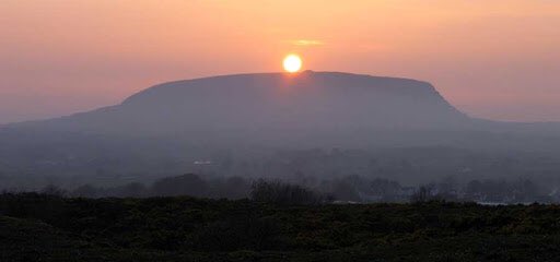 in a 12 m high stone monument on the summit of Knocknarea in County Sligo. She is supposedly buried upright facing her enemies in Ulster.