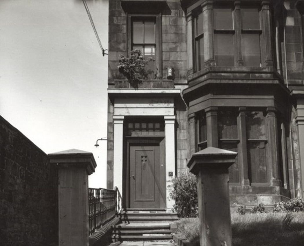 La casa de los Mackintosh era un adosado de estilo victoriano que hacía esquina en un elegante barrio de nueva construcción. Y como veis, sí que tenían una puerta de verdad, que aunque no estaba al nivel de suelo, sí que tenía sus escaleritas. Lo normal, vamos.