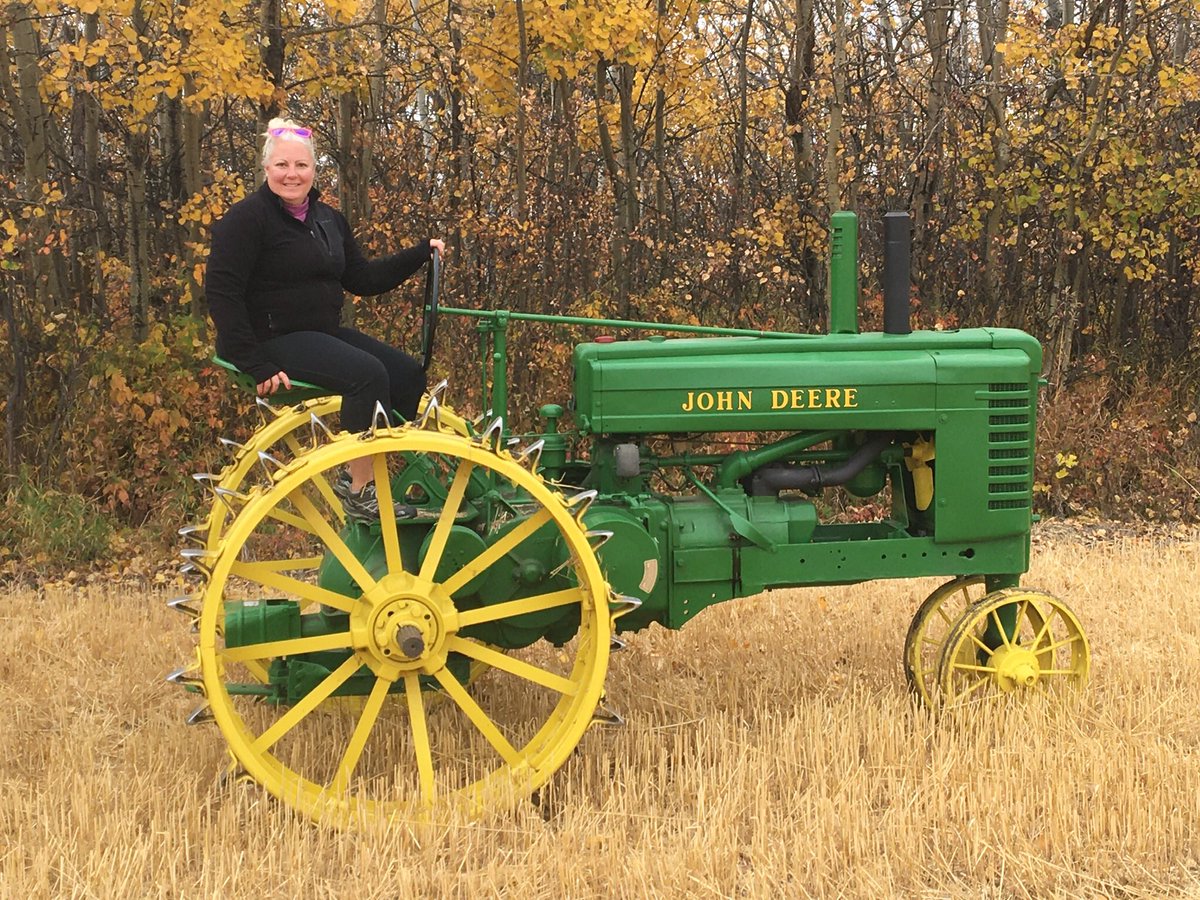 This is me on my 1943 #JohnDeere A tractor. Hubby <a href="/DeereWyld/">Wyld Deere 🇨🇦</a> collects toys and I’ve become quite possessive of this beauty. She’s all tucked in for a long winters sleep now but we had a fun fall outing. #seventysevenyearsyoung #rowcrop #twostroke #crownjewel #donttouchmytractor