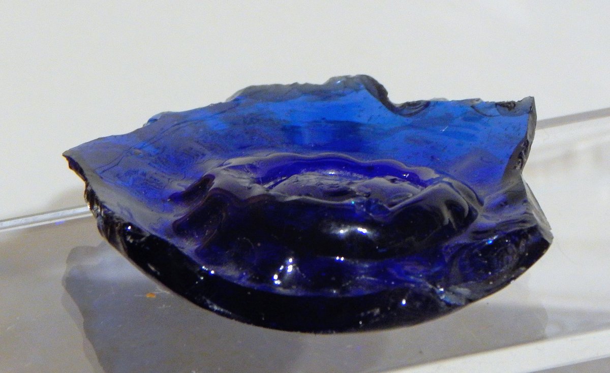 An Anglo-Saxon glass mount and the base of a blue glass inkwell found at the intriguing 7th- to 9th-century 'island' site of Little Carlton, Lincolnshire.