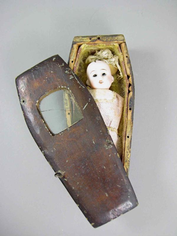 The dolls were usually left at the child's grave site, but some families would keep them in the home as a memento - in a small glass coffin, a frame, or even a crib.