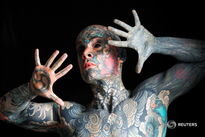 Reuters's tweet photo. A schoolteacher whose body, face and tongue are covered in tattoos and who has had the whites of his eyes surgically turned black said he was prevented from teaching at a French kindergarten after a parent complained he scared their child https://t.co/HVOQx8bQBO https://t.co/NM31rhz98b