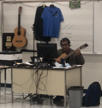 LeavittMS's tweet photo. Mr. Lopez leads his students in today's guitar lesson. Guitar is one of the fine arts courses that has teachers playing instruments live with students during distance learning. #leavittms @ClarkCountySch https://t.co/tAv2L6UgDg