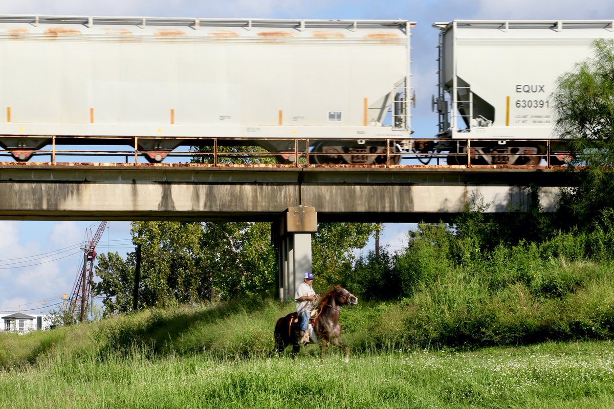 The passing rider doesn’t bat an eye — industry has been part of these neighborhoods since before either the Ship Channel or the greenway existed.