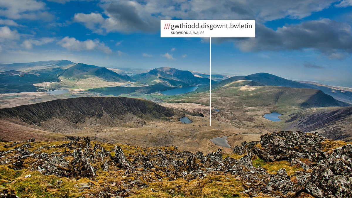 Mountainous landscape in Snowdonia, Wales. what3words address sticker is in the welsh language.