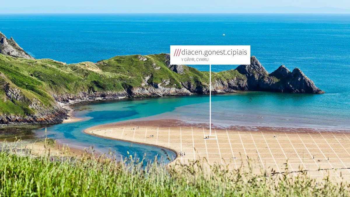 Sandy beach, with sea stretching out into the distance. what3words address is in welsh and reads ///diacen.gonest.cipiais