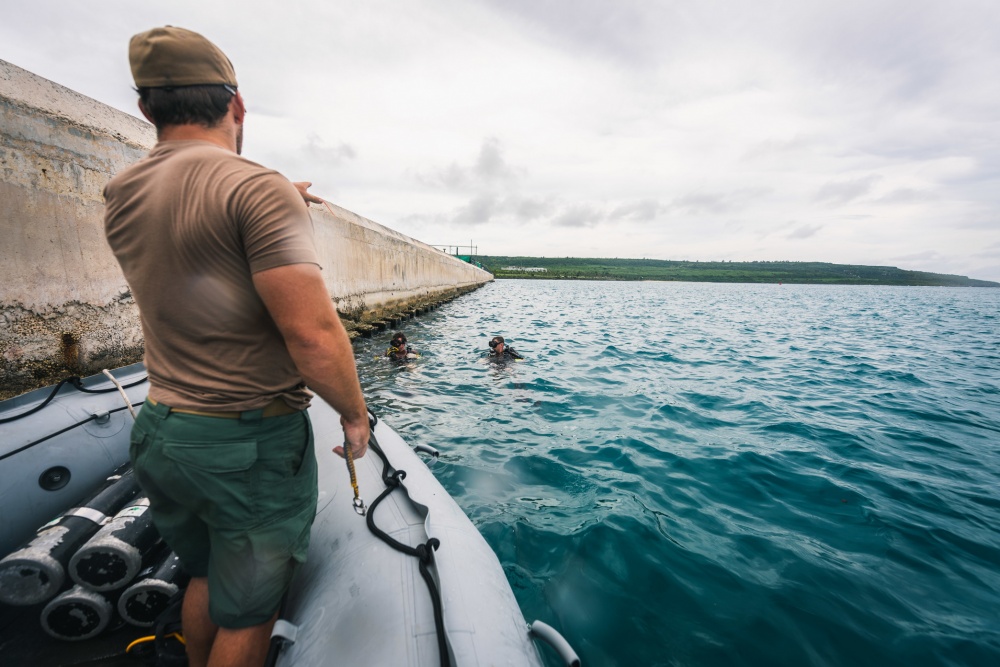 USPACOM's tweet photo. Seabees assigned to Underwater Construction Team #UCT2 inspect a pier during #SCUBA operations within the Tinian Harbor in order to ensure a #FreeandOpenIndoPacific https://t.co/iFzh7Wni9k
