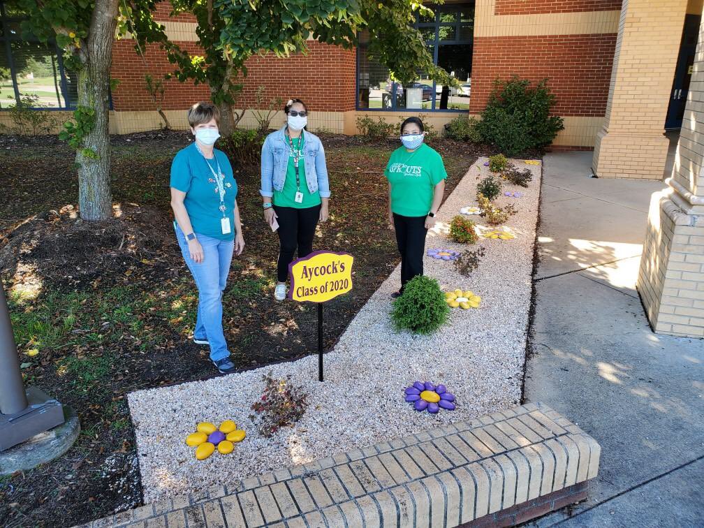 AYCOCKSCHOOL's tweet photo. These three ladies are at it again this Wednesday afternoon! Adding the rocks our students painted last year to our flower beds out front @AYCOCKSCHOOL! Thank you @Lowes for the grant! The students will love seeing this! @scompton2015 @EvaJennings12 @lsoto_liliana #weareaycock https://t.co/DuIIPzSYON