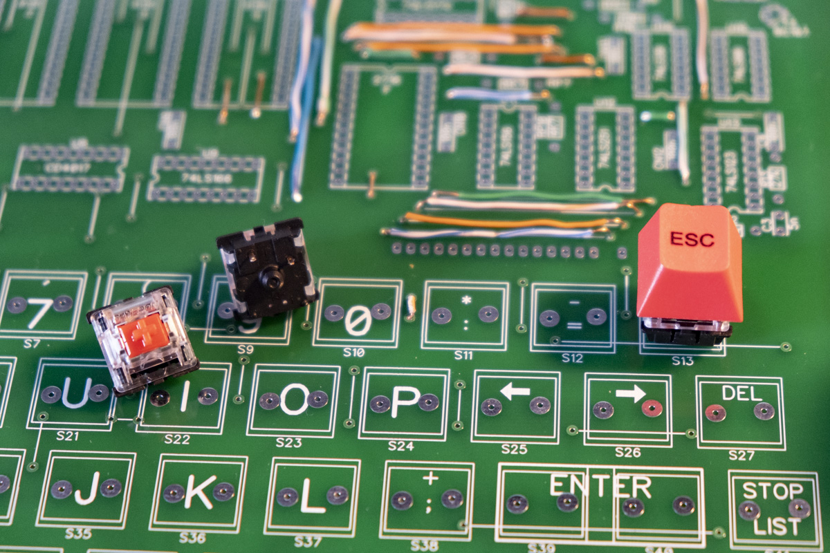 So here's the problem. I got these Gateron switches, but their connectors are slightly different from what's on the PCB, so they don't fit nicely. I'm experimenting with soldering some extra copper wire to get around this, but I'm not sure if it's wise.