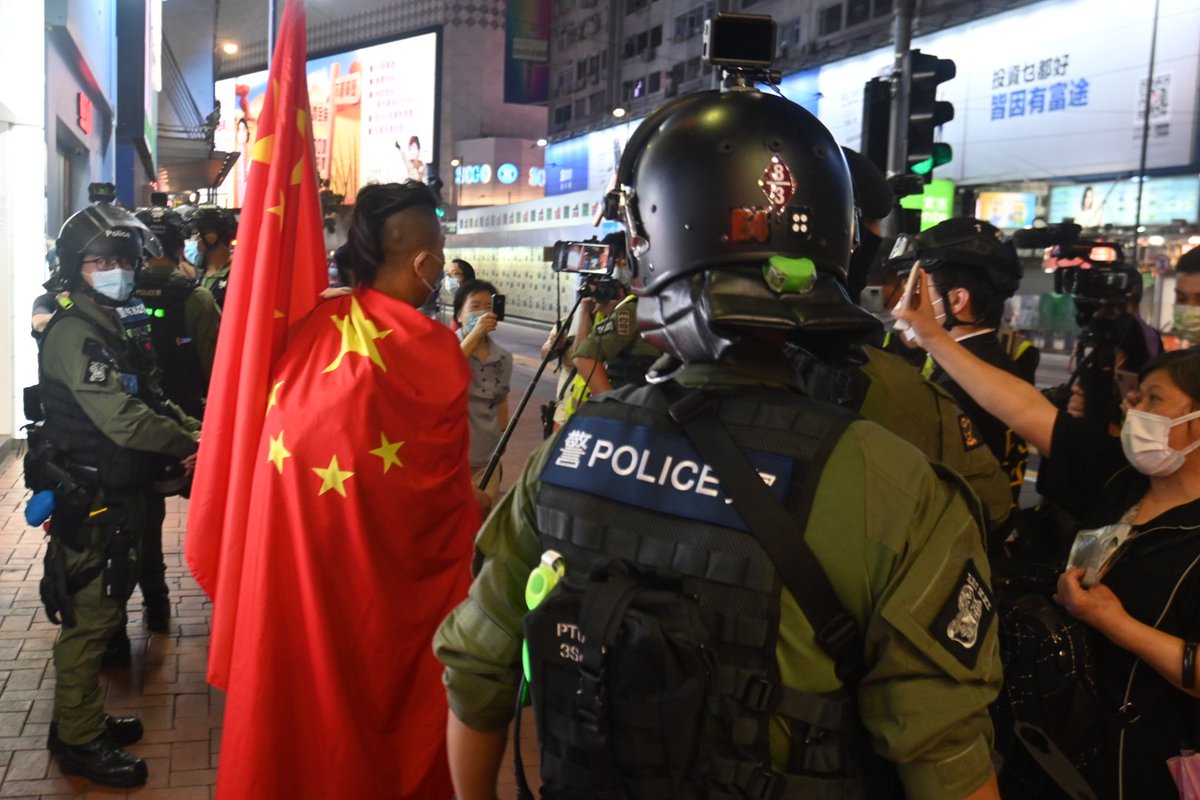 Police seem somewhat confused by his antics. A local who seems unaware of his identity also taking his act of overt nationalism as a genuine one and is waving a picture of Mao at his face.