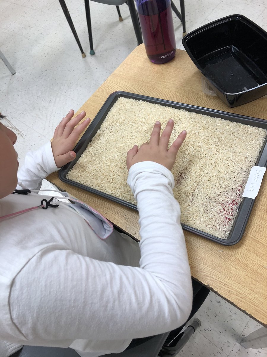Practicing letter sounds with our rice trays.
