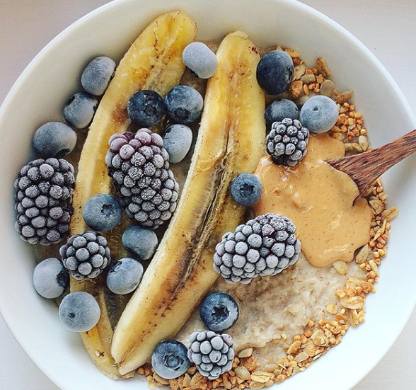 Warming cinnamon oats, caramelised banana, frozen berries and a sprinkle of granola - @vicsveggiekitchen is definitely sweetening up the rainy day blues 😋 #breakfastbowl #granola