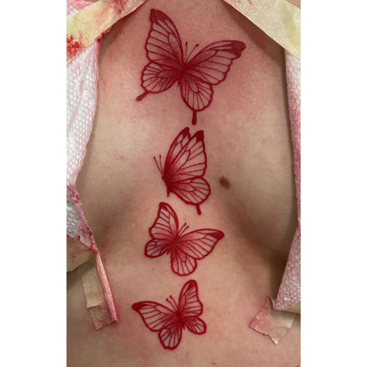 Red butterfly sternum tattoos