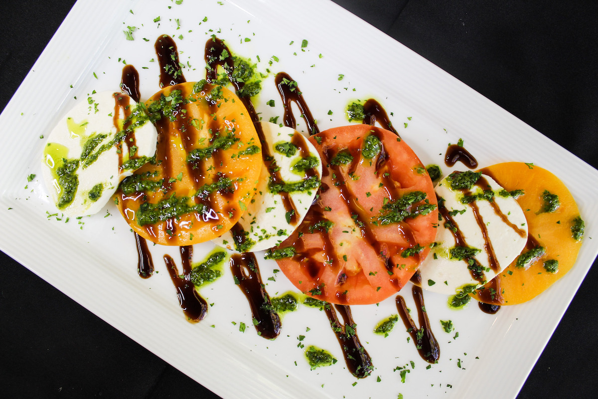 CAPRESE SALAD 🥗  
 
fresh mozzarella, seasonal tomatoes, basil pesto, and balsamic reduction. 🍅