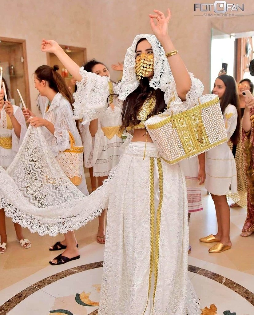 Step 4: The HammamThe bride, her close female relatives and her friends go to the hammam (~spa)dressed in a traditional dress and covered in sefseri or Haïk. They carry hammam baskets with traditional motifs.It's a relaxing girls-only day with chants, dancing and self care.