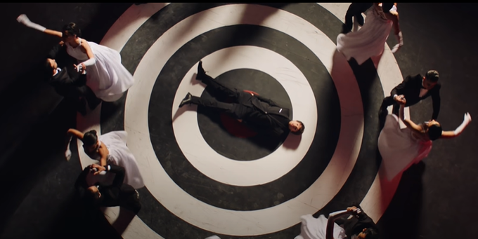 Of course, we have L laying on a literal target as the hetero couples dance around him, looking lost and alone, constantly waiting. Feeling targeted by this world of pretense and heterosexuality, feeling like he's living a lie. This is a coming out song in a lot of ways.