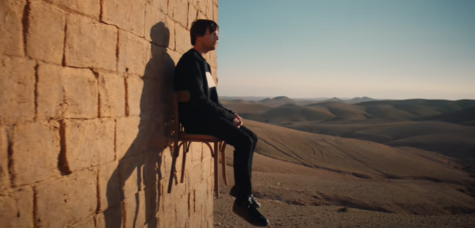 The MV ends with his Oasis shot on that chair, up on that high wall, waiting, fighting for his freedom.