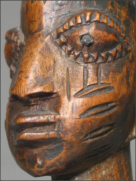 The completed ibeji figure is carved as an adult, rather than as the deceased infant, in a mythological form that depicts the concentrated calm of a Yoruba artist. When the carving is completed, the artist is given a feast and payment as determined by the Orishas.