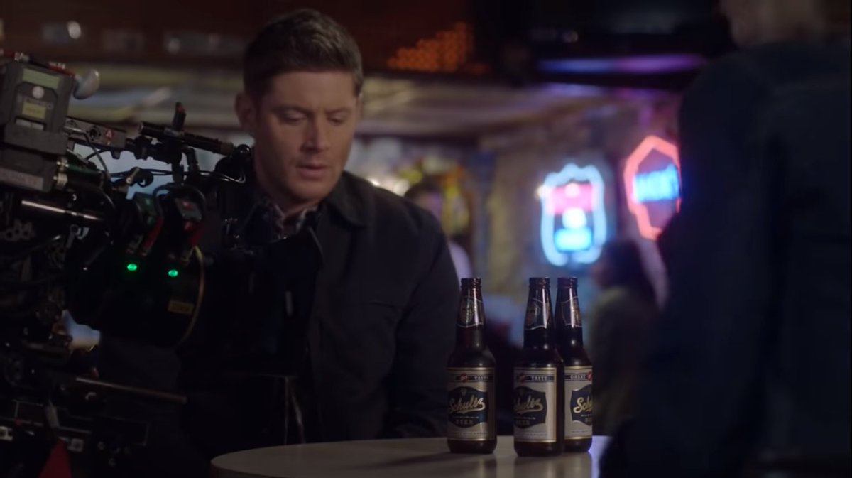 This seems Dean interrogating a victim or someone related to a case and since there are three beers, probably there's Sam too in the scene.