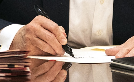 ZOOM:  @realDonaldTrump appears to be signing his name to a blank sheet of paper in this photo.