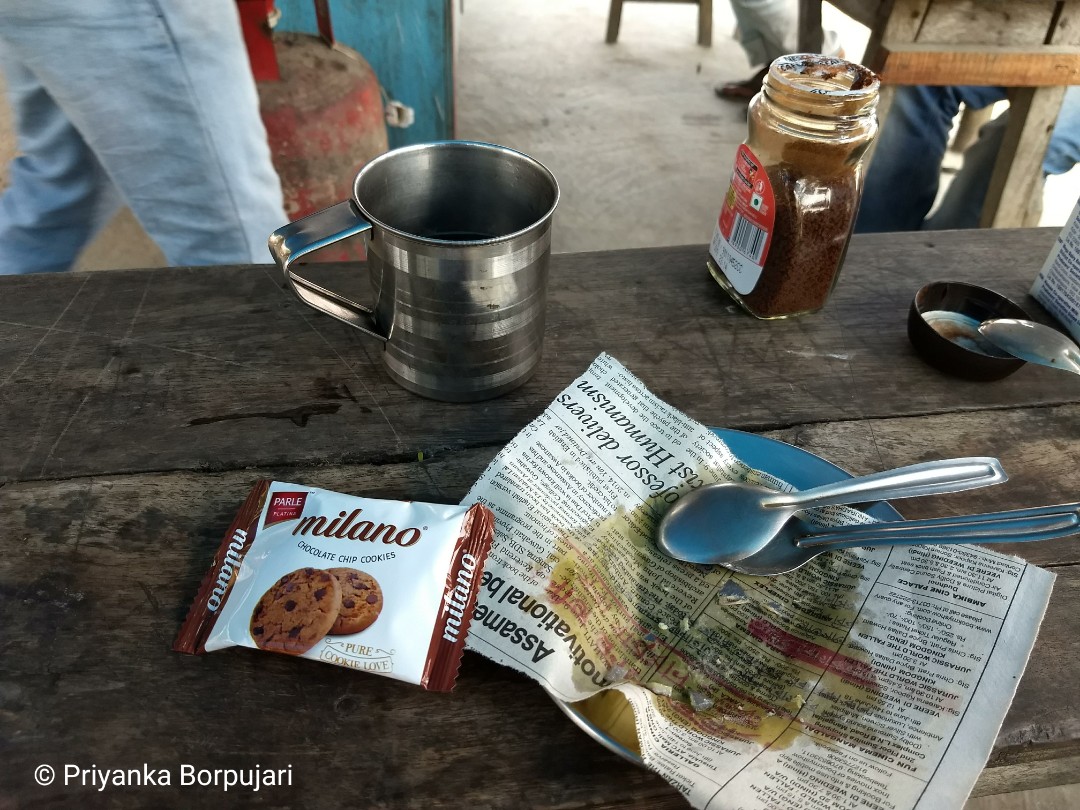 Power boost for a long  #EdenWalk day: fried fritters (gone already), Nescafe drunken out of multipurpose steel mug, chocolate treat. @PaulSalopek ate his own; then eyed the one in my bag, claiming it was his.Wrapper from the one he ate—crucial evidence—was missing.Chapar, Assam