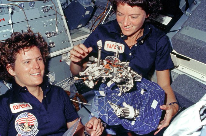 Kathy Sullivan and Sally Ride float in microgravity on board the space shuttle.