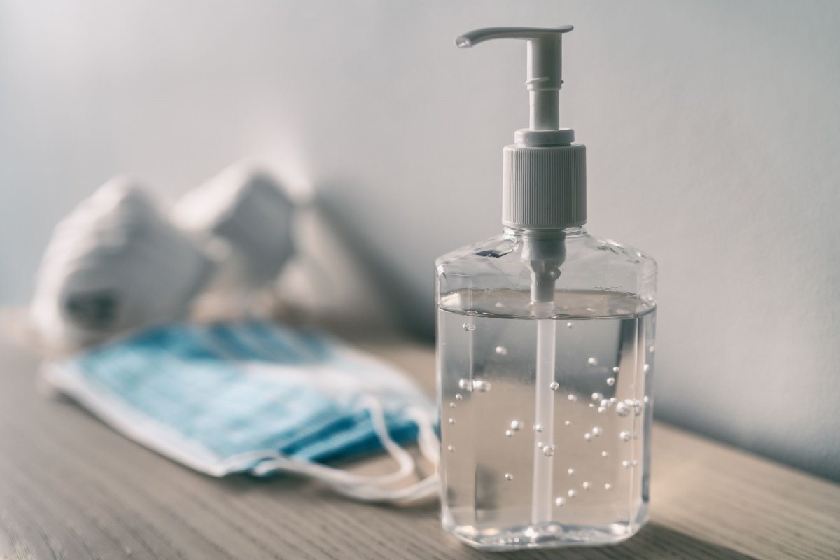 Photo of large hand sanitizer and face masks in background