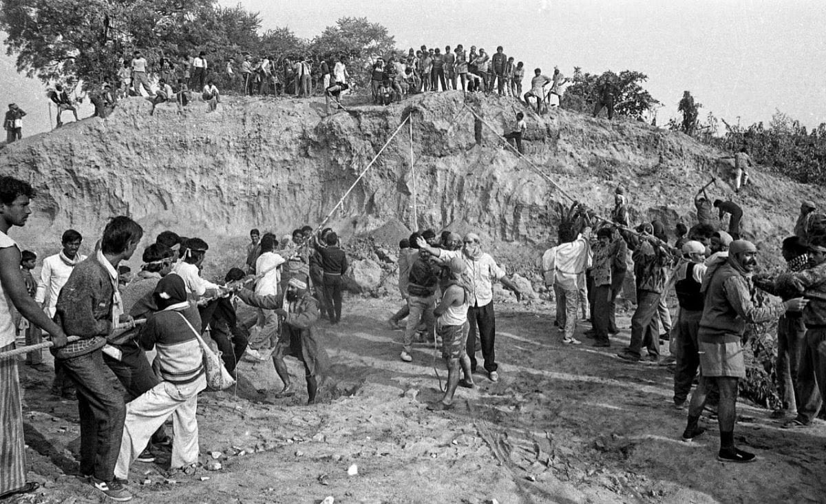 A man, with his face covered, instructs kar sevaks during the rehearsal