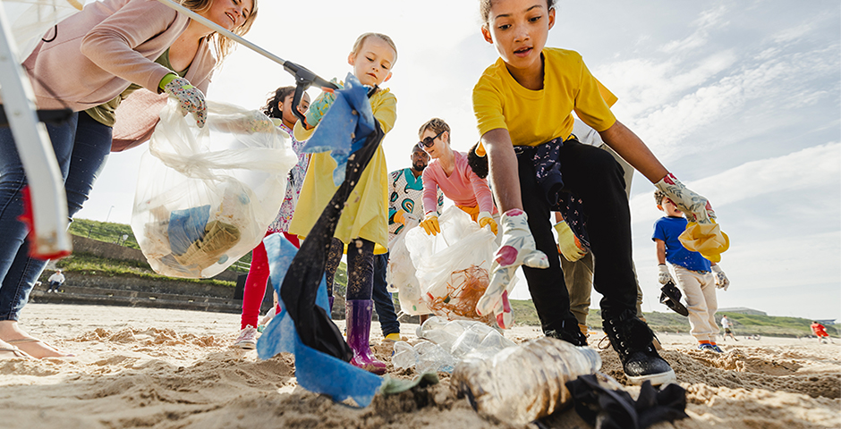 a group of kids cleaning up a beach