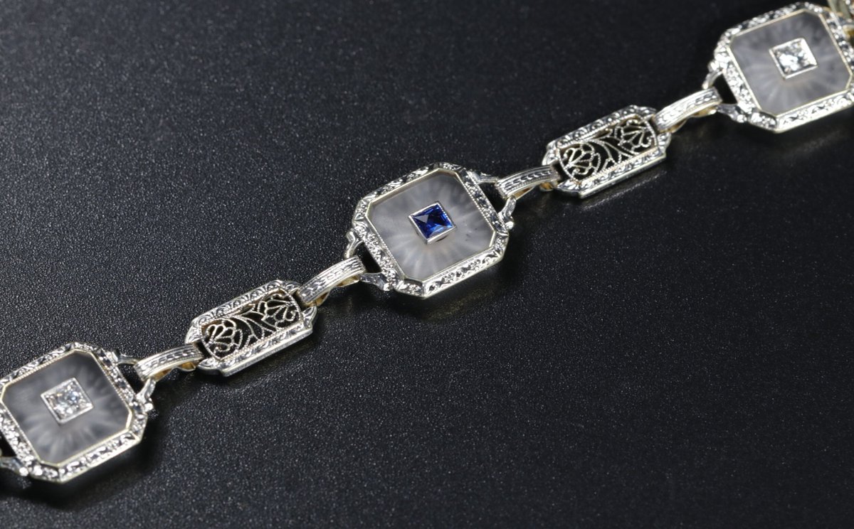 An antique camphor glass bracelet (that's the milky starburst stuff set into the square links) with a lovely sapphire set into the center. Gimmie.