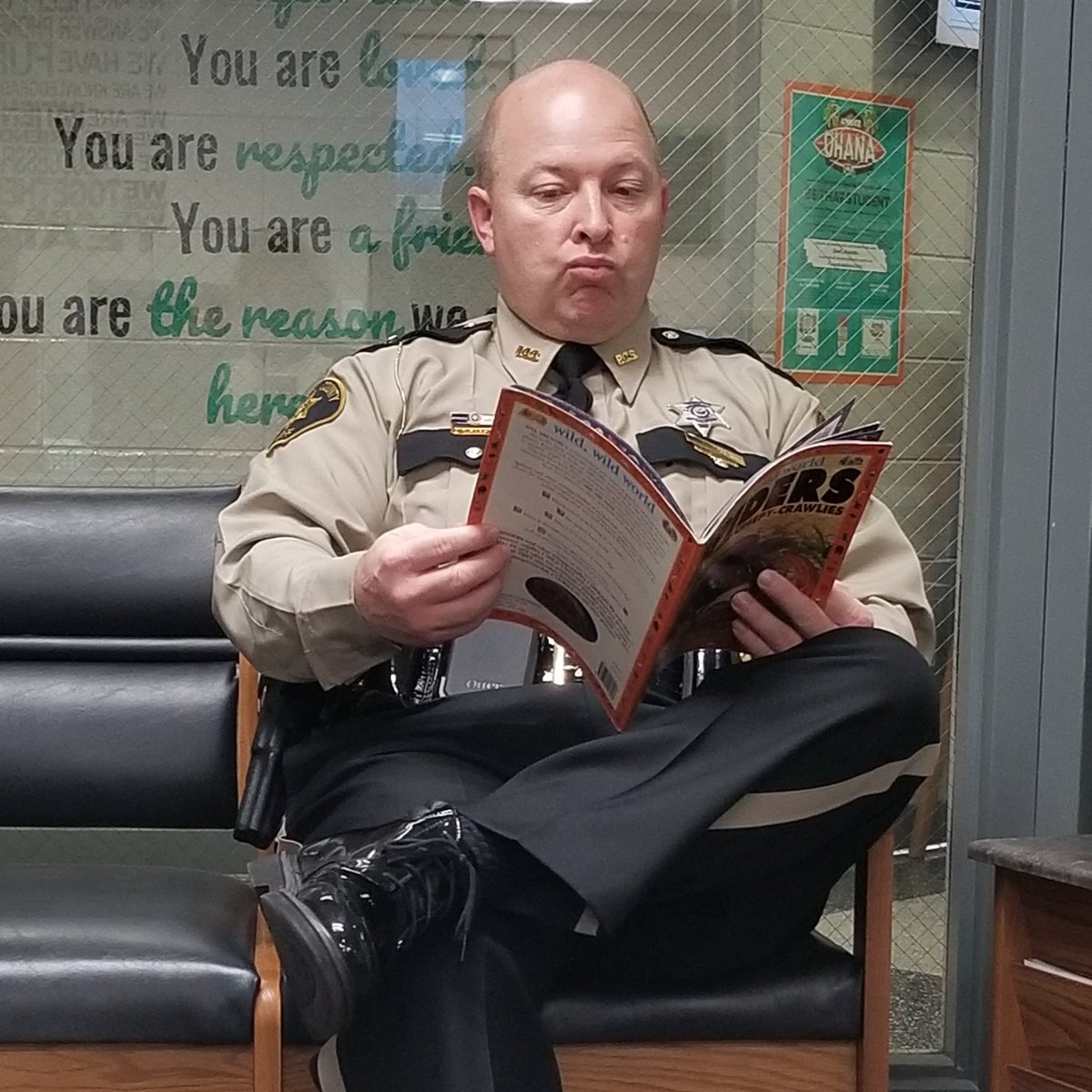 Shoutout to SRO Doug Boyd, seen here checking out a book while waiting for afternoon dismissal at Shopville Elementary in Pulaski County. We see you, SRO Boyd!
