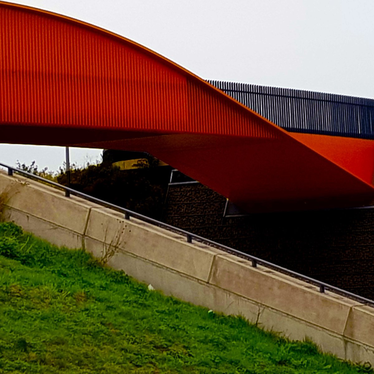 OffcutStudioUK's tweet photo. Loving the simple lines on this bridge over the A13 by the Stratford Olympic Park in East London. Great colour combo between the green grass, orange metal and grey concrete. https://t.co/d4Ubxj0ApG