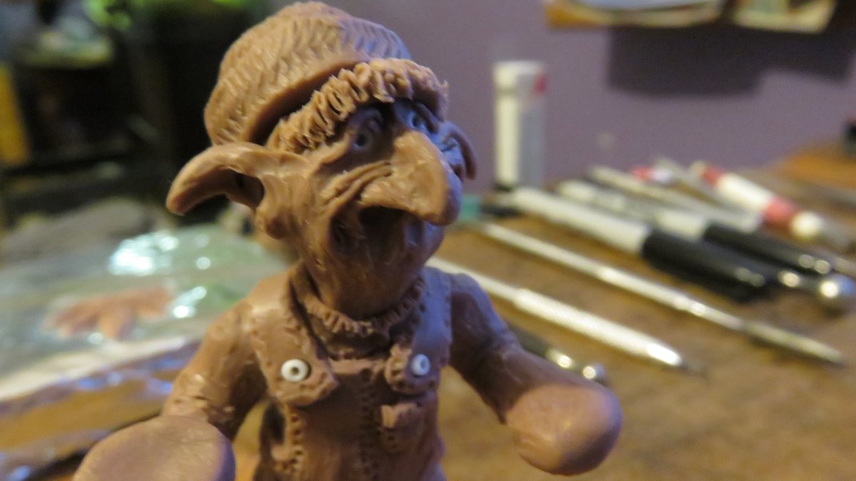 Next, I add a layer of clay. Then I start shaping and cutting away, and adding onto, and making detail, etc. He will have a pot plant in his right hand, and he will be politely passing a pipe full of pot, or a joint maybe. Working on his overalls right now. Yes, that's his beard.