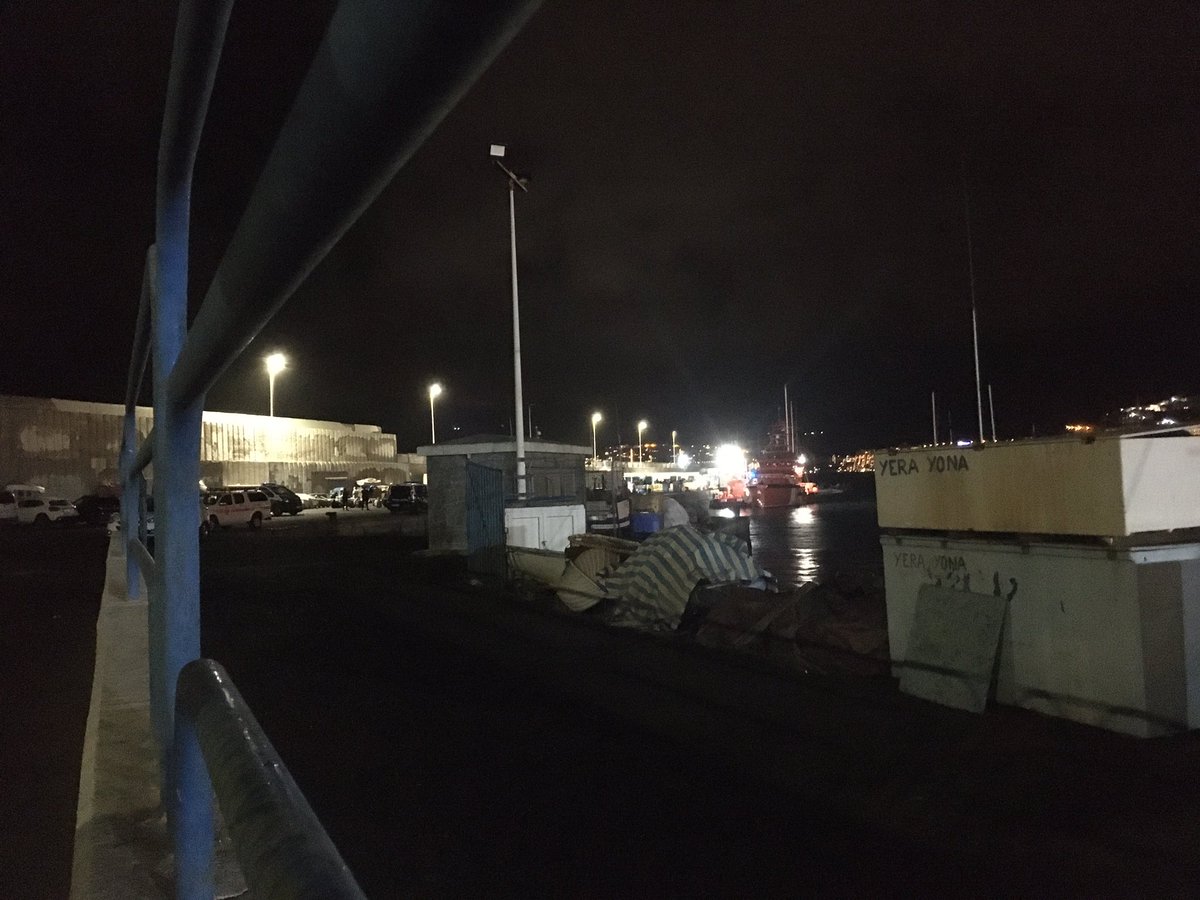 javierbauluz's tweet photo. 23,15 h. Día 13. Llueve fuerte sobre chavales sentados en el suelo a la intemperie vigilados por policías. Campo de concentración de #migrantes. Muelle Arguineguin #Canarias #Spain Distancia 250 mts Prohibido 🚫 el paso a #periodistas por Interior https://t.co/8ZzGvtlmNf https://t.co/QEv46Tu7ye