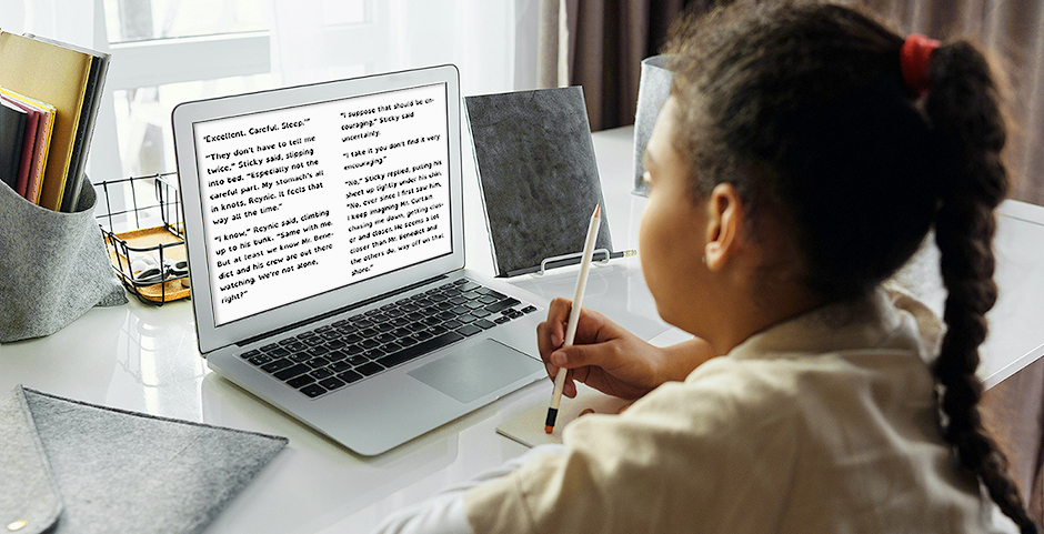 young child looking at a laptop screen that displays dyslexic font