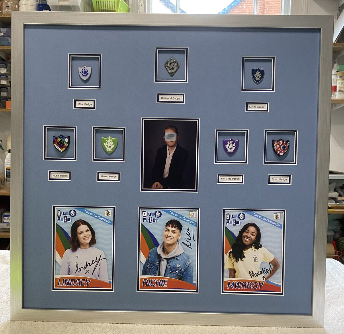YPFOld's tweet image. A great collection of Blue Peter badges, the young recipient in the centre along with photos of the presenters. Invisible glass. @Linds_bluepeter  @mwaksybluepeter #WorcestershireHour