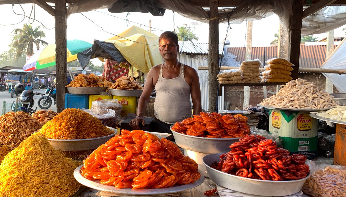 A street sweets vendor waiting for customers in a village in Barpeta, India.  
#india #people #streetvendor