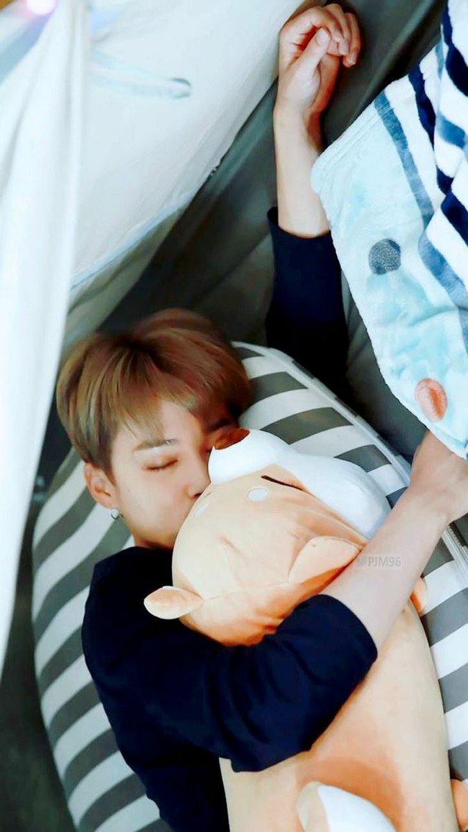 Jimin lying by your side cuddling stuffies,
