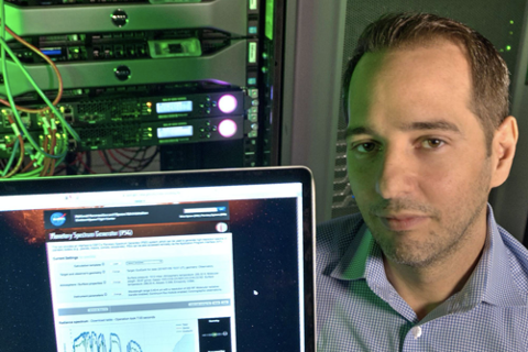 Geronimo Villanueva poses with an open laptop displaying his planetary research.